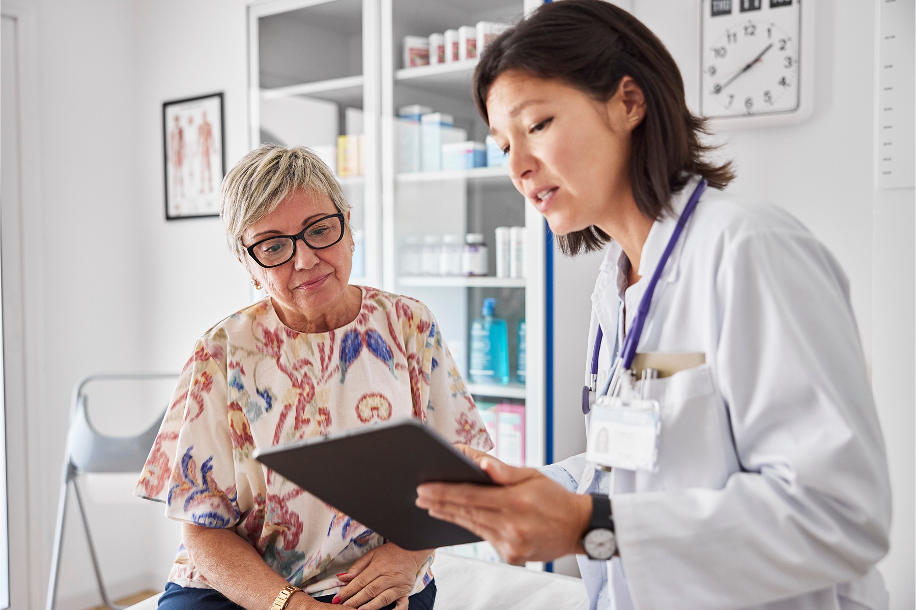 Medical specialist reviewing file with patient